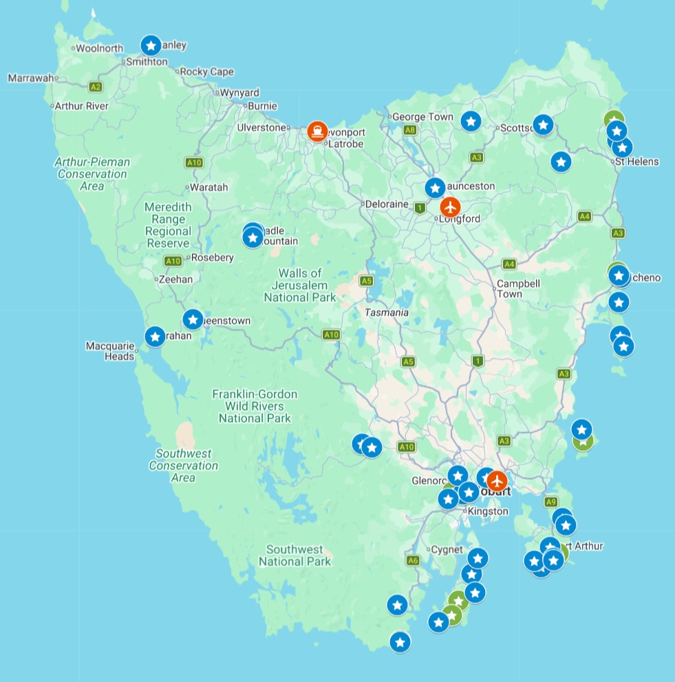Map of Tasmania with colored markers highlighting various locations across the island including Hobart, Launceston, and coastal towns. Blue and green star icons and orange symbols are scattered along the east coast, south coast, and inland areas, suggesting points of interest or stops on a travel route. Major roads, national parks, and regional labels are visible to provide geographic context.