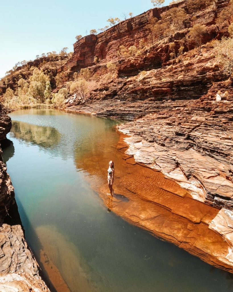 Woman standing on shallow water in a gorge in Karijini National Park, Western Australia