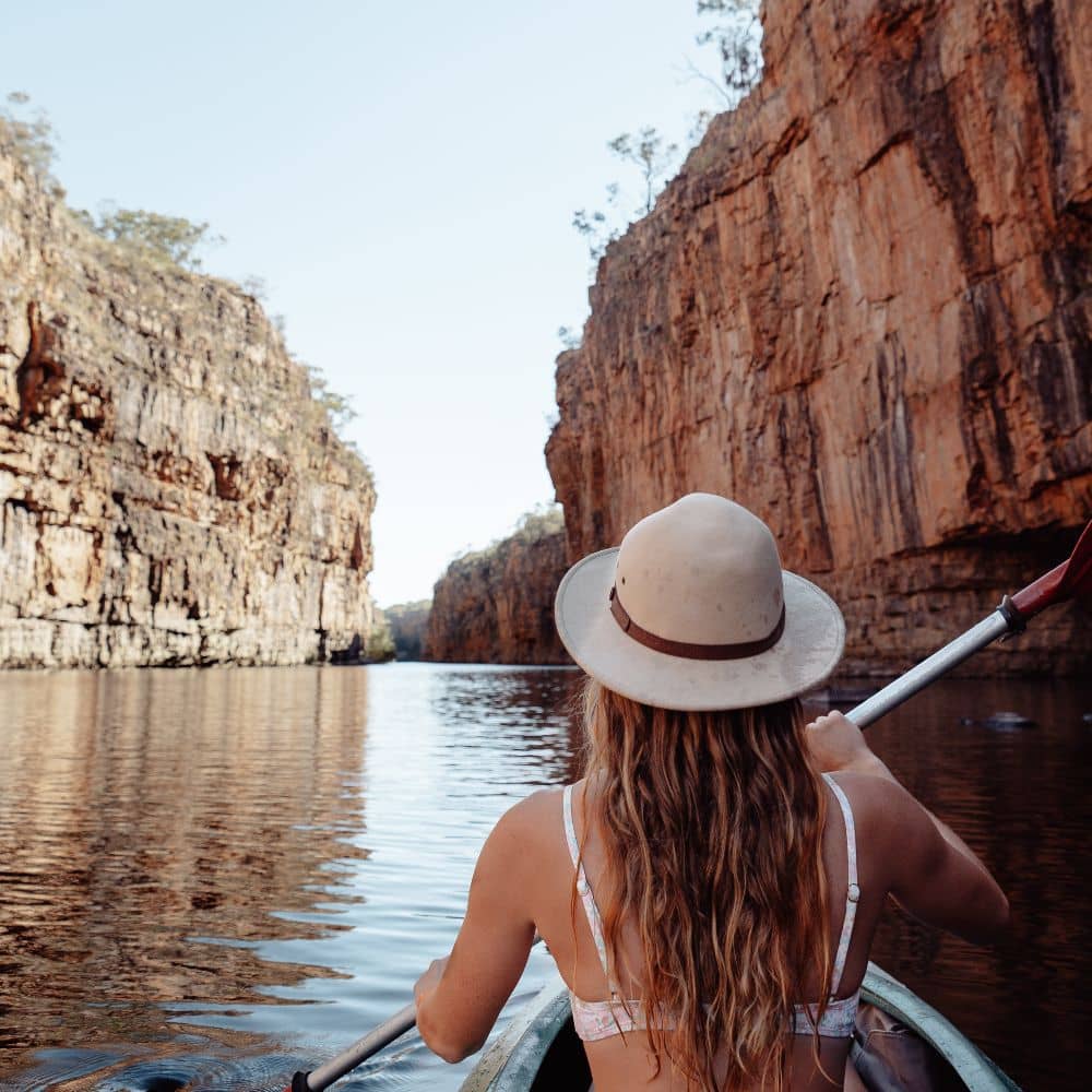 Woman in kayak while kayaking down a body of water. One of the ways to enjoy the best hiking of the NT. This popular spot is located at the Nitmiluk National Park in Alice Springs, Northern Territory.
