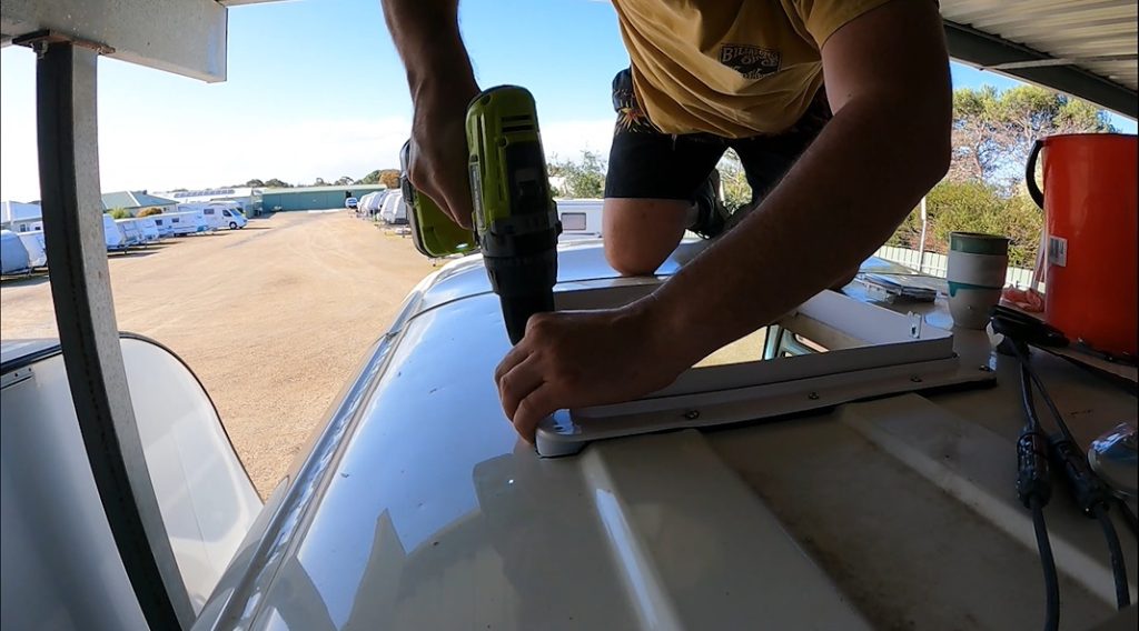 Screwing the MaxxAir fan into the roof of the Toyota Coaster