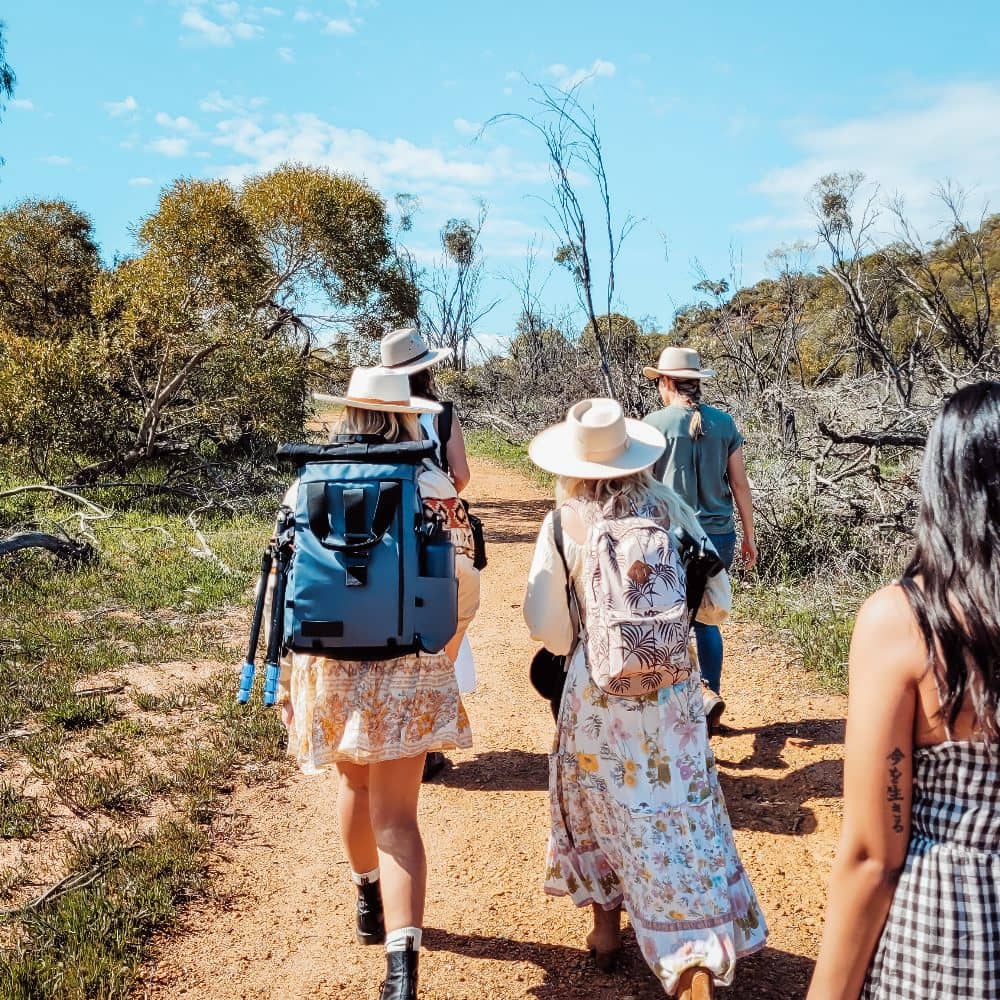 A group of tourists exploring to see the Western Australian wildflowers under the bright, expansive sky.