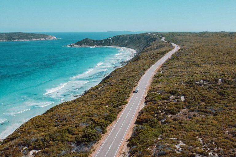 Bus driving along the Great Ocean Drive in Esperance, Western Australia. Scenic view of the ocean to the left and green landscapes to the right