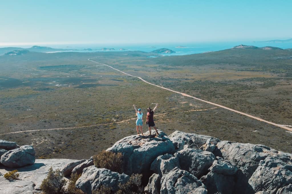 Happy couple on top of mountain, they have just transitioned from 9-5 to remote or online work.