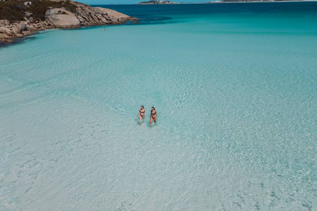 Two women walking in the waters of Wharton Beach in Esperance WA