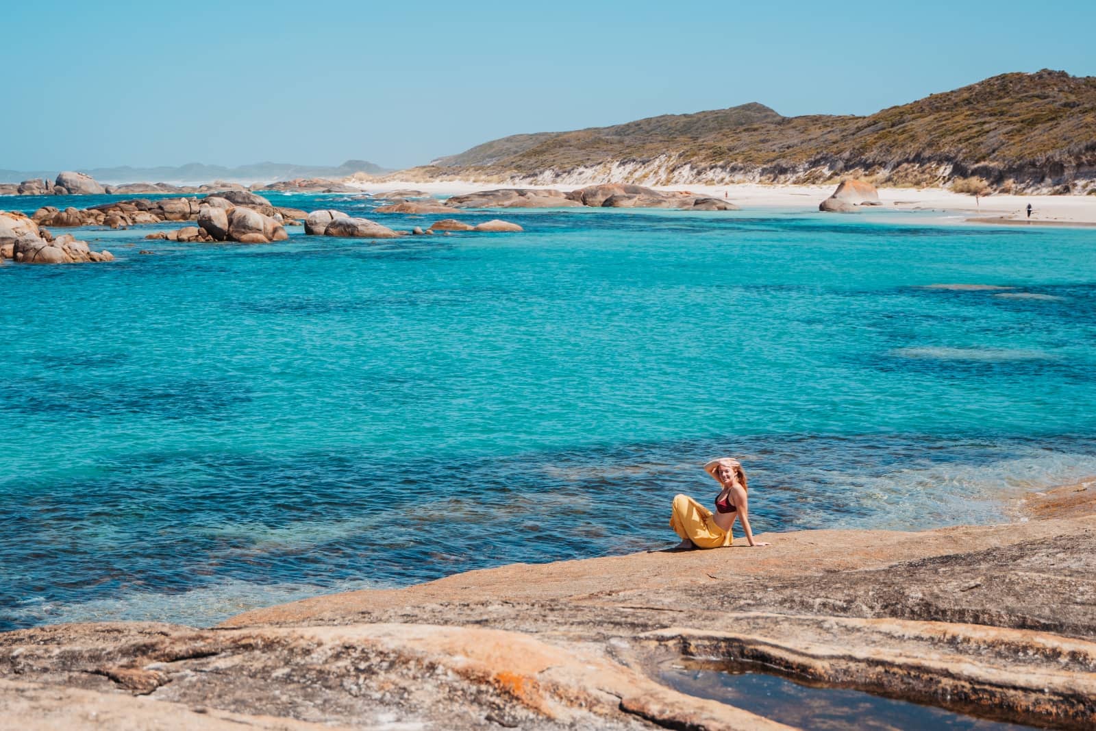 A woman at a turquoise beach with rock formations in Denmark Western Australia