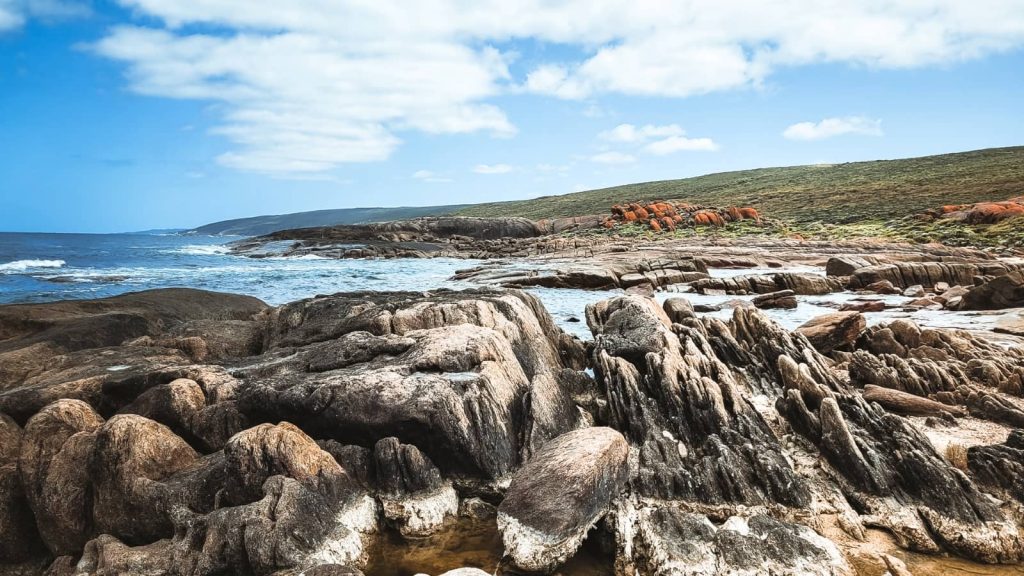 Expansive view of rugged coastline in Augusta, Western Australia, where textured rock formations meet dynamic blue waters, ideal for landscape photography, outdoor activities, and more things to do in Augusta
