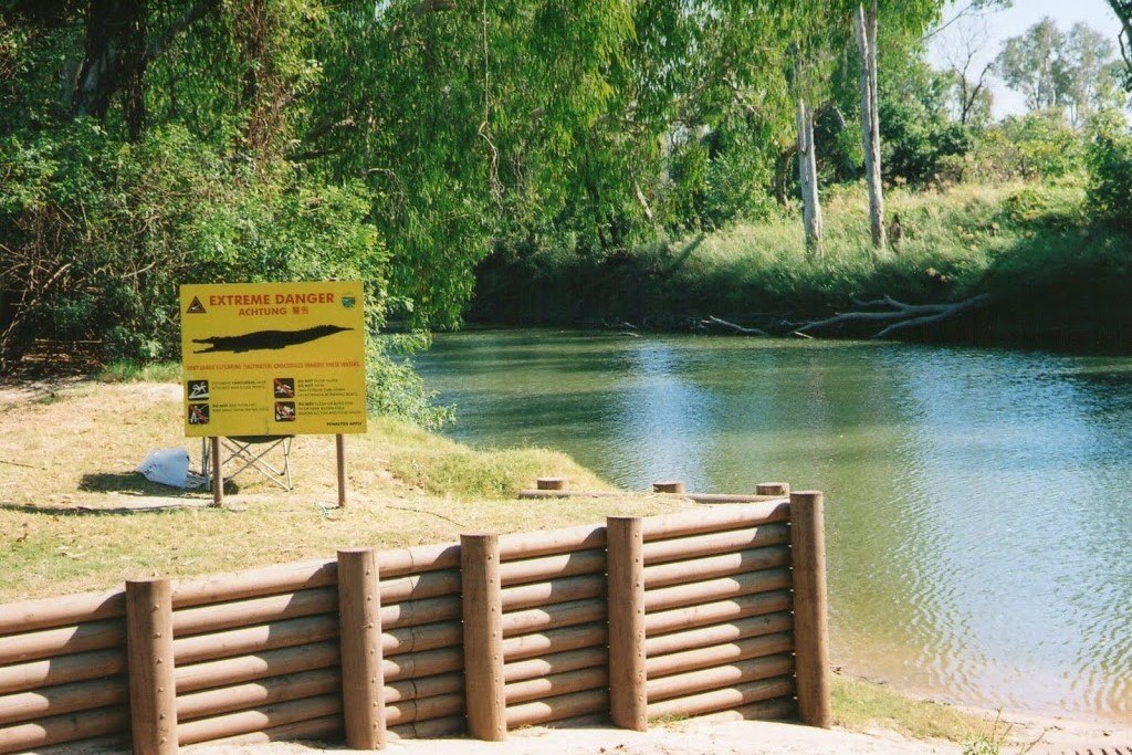 A crocodile warning sign placed at the East Alligator River in Kakadu National Park, Northern Territory. The sign clearly displays the message "Extreme Danger" in multiple languages, cautioning visitors to be wary of saltwater crocodiles in the area. 