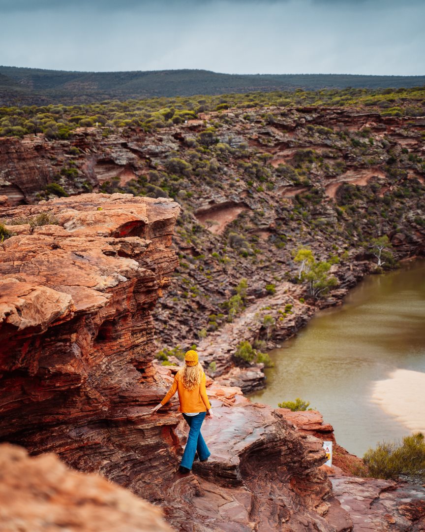 A woman hikes in Nature's Window in Kalbarri, Western Australia. This image shows easy Kalbarri walks