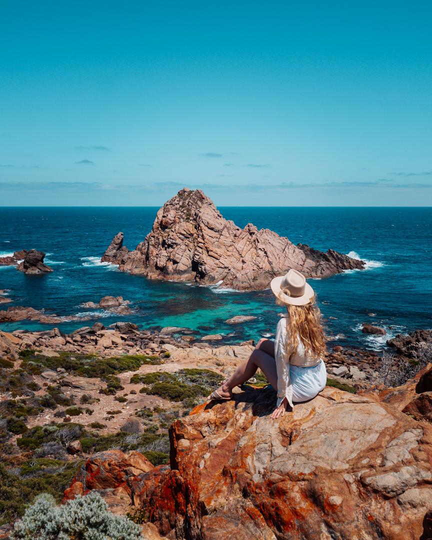 Bec from Salt and Charcoal sitting at lookout overlooking Sugarloaf Rock in Margaret River Region.