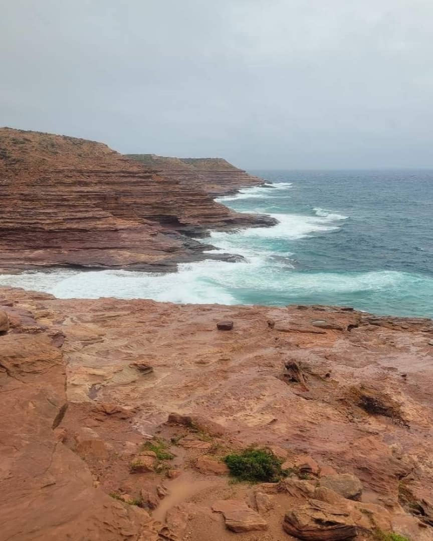A view of the rugged red cliffs and crashing waves at Eagle Gorge in Kalbarri, Western Australia.