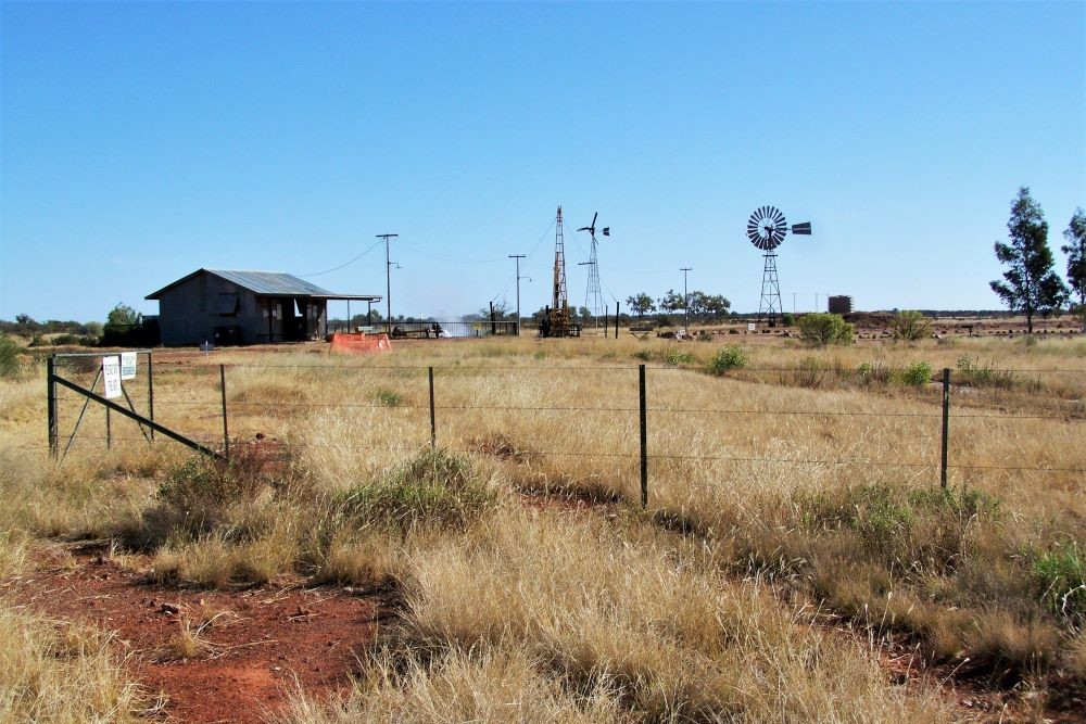 The historic hydroelectric plant in Thargomindah, surrounded by dry grassland, windmills, and an outback landscape, showcasing a unique thing to do in Thargomindah.