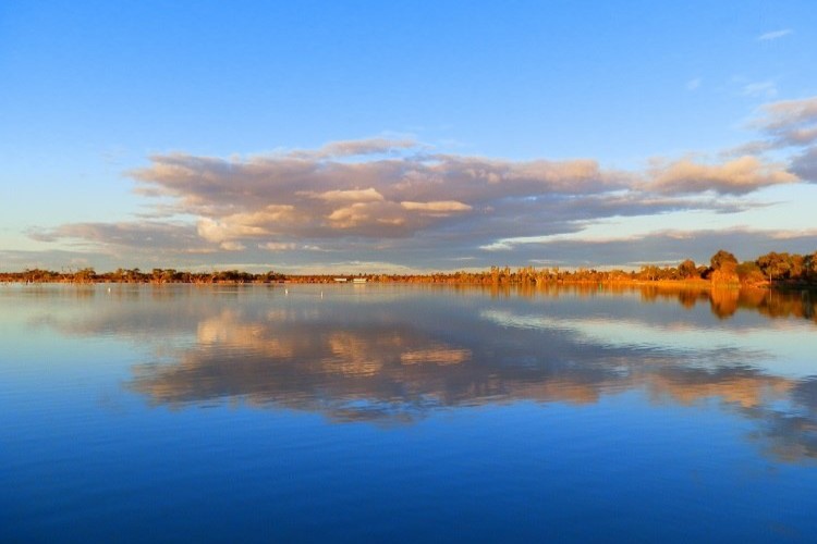 Late afternoon at Lake Cullulleraine, with calm waters reflecting clouds and a clear blue sky, perfect for relaxing activities among things to do at Lake Cullulleraine.