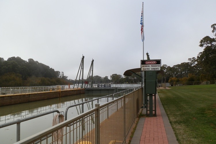 A view of Lock 9 on the Murray River, with a sign warning about prohibited swimming due to electric currents.