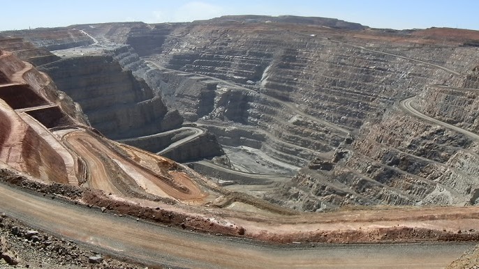 A panoramic view of the Super Pit Kalgoorlie, showcasing the terraced walls and winding roads of the massive open-pit gold mine in Western Australia.