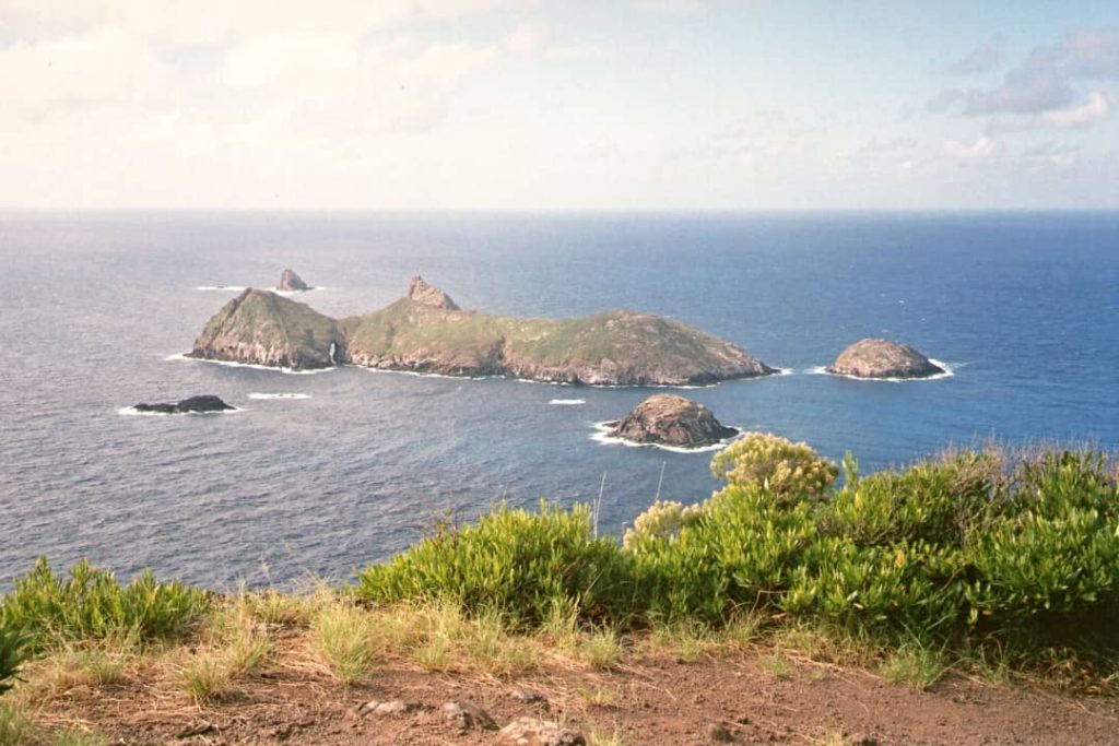 A panoramic view of the Admiralty Islands from Malabar Hill at Lord Howe Island, characterized by towering pinnacles and vibrant coral reefs beneath the clear blue waters.