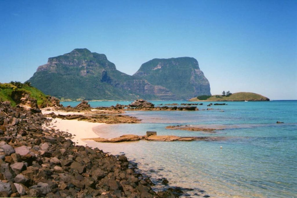 Mounts Gower and Lidgbird on Lord Howe Island, New South Wales, Australia, rise majestically behind a stunning beach with golden sands and turquoise waters.