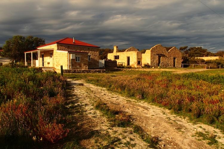 A dramatic late evening view at Inneston in Dhilba Guuranda-Innes National Park, Yorke Peninsula, South Australia, with historic buildings illuminated by the golden glow of the setting sun