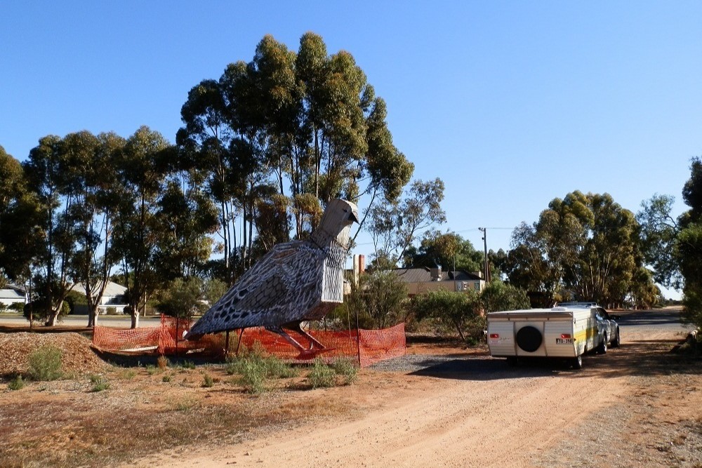 Big Mallee Fowl sculpture near a parked trailer.