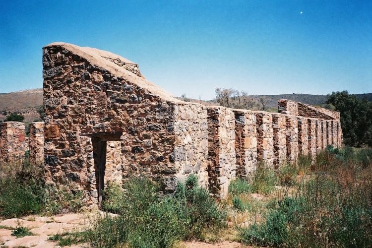 Historic Kanyaka Ruins in the Flinders Ranges, a must-see stop on a Flinders Ranges itinerary, with weathered stone walls and clear blue sky in the background.