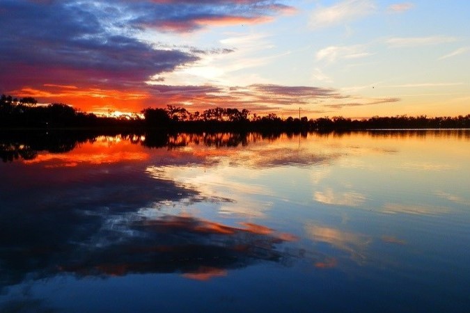 A stunning sunset at Lake Lascelles, one of the top things to do in Hopetoun, Victoria, featuring vivid colors from deep blues to fiery reds and oranges. The vibrant hues reflect on the calm water’s surface, creating a breathtaking mirror-like effect.