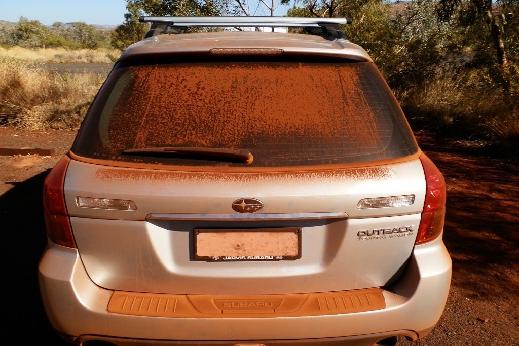 A car covered in red dust, a common sight for those visiting Karijini, one of the things to do near Tom Price.