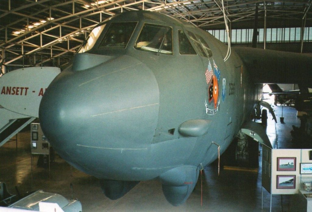 B-52 bomber plane displayed inside the Australian Aviation Heritage Centre in Darwin. The aircraft's large, grey fuselage and cockpit are visible, along with some insignia painted on the side. The indoor setting highlights the aircraft's immense size and historical significance.