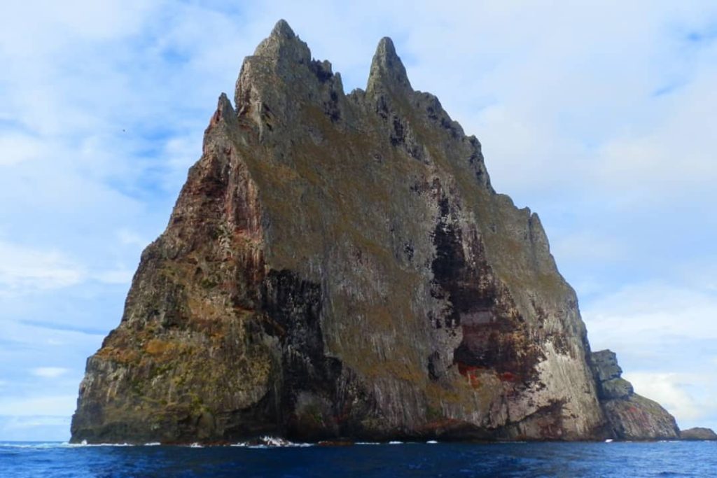 The sheer west-facing side of Balls Pyramid, a towering rock formation off Lord Howe Island, Australia, rises dramatically from the ocean.