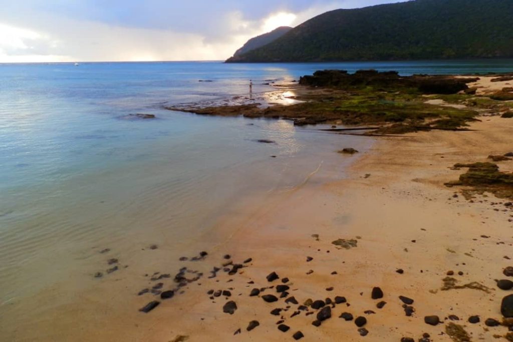 A fisherman casts a line in the calm water at sunset on Lord Howe Island.