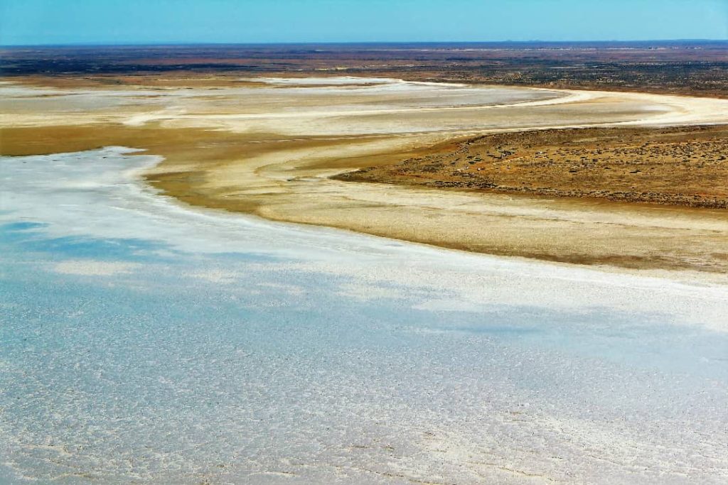 Expansive view of the salt flats and dry terrain at Halligan Point, overlooking Lake Eyre in the outback of South Australia, with vast, open land stretching to the horizon.