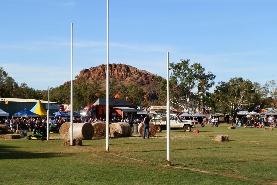 Kelly's Knob viewed from the Kununurra Showground during an agricultural event, with crowds, tents, and hay bales, showcasing one of the lively community activities among the things to do in Kununurra.