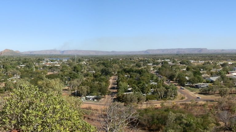 A panoramic view of Kununurra from Kelly's Knob Lookout, showcasing the town's greenery and surrounding hills.