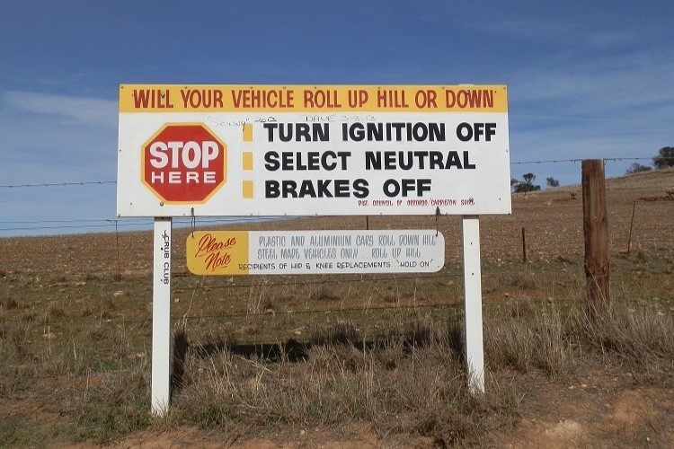 Instruction sign at Magnetic Hill, South Australia, explaining how vehicles appear to roll uphill.