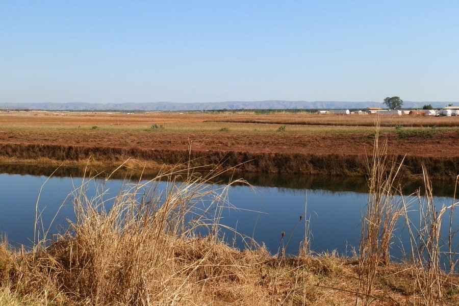The Ord Irrigation Scheme in Kununurra, with expansive fields and a calm irrigation channel, showcasing the region's agricultural landscape.
