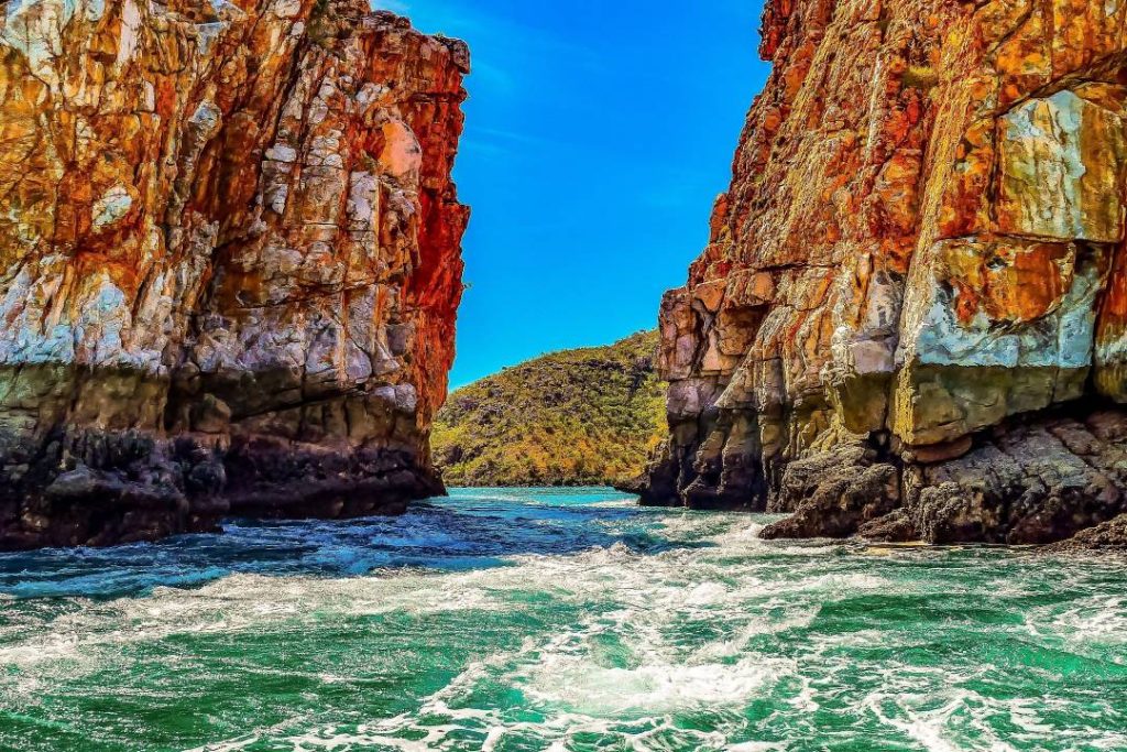 A close-up view of the powerful waters rushing through the iconic Horizontal Falls, framed by rugged red cliffs.