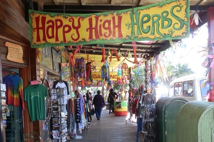 A colorful storefront in Nimbin, with vibrant decorations and a large "Happy High Herbs" sign, offering a glimpse into the unique shopping and cultural experiences—one of the eclectic things to do in Ballina NSW for visitors exploring local arts and crafts.