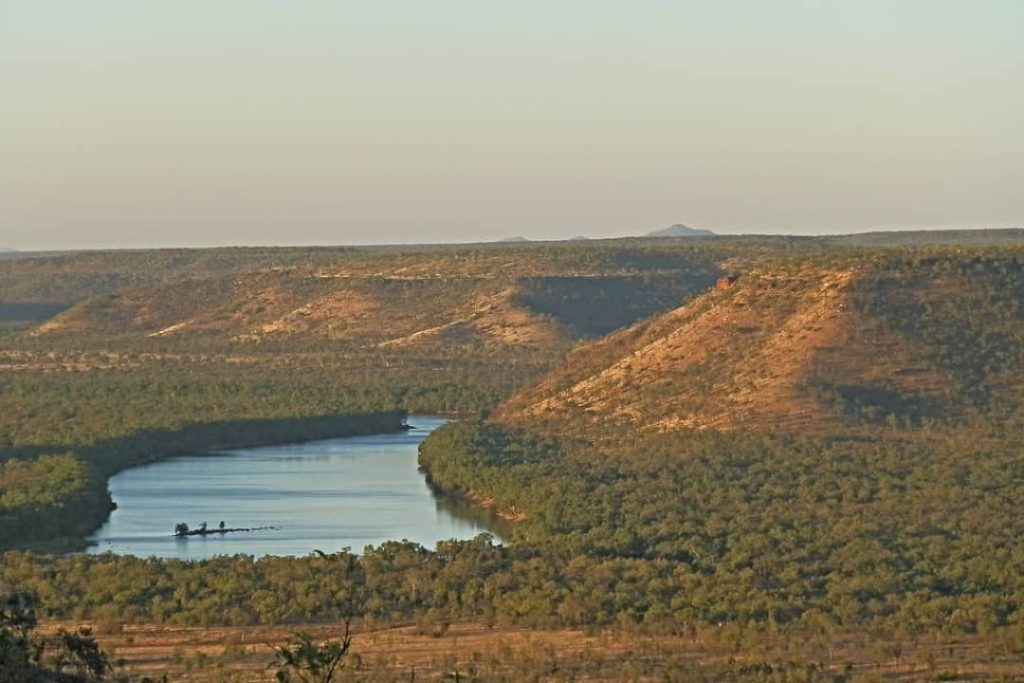 Sunset view over the winding Victoria River from the Escarpment Lookout near Timber Creek, casting a warm glow on the surrounding hills.