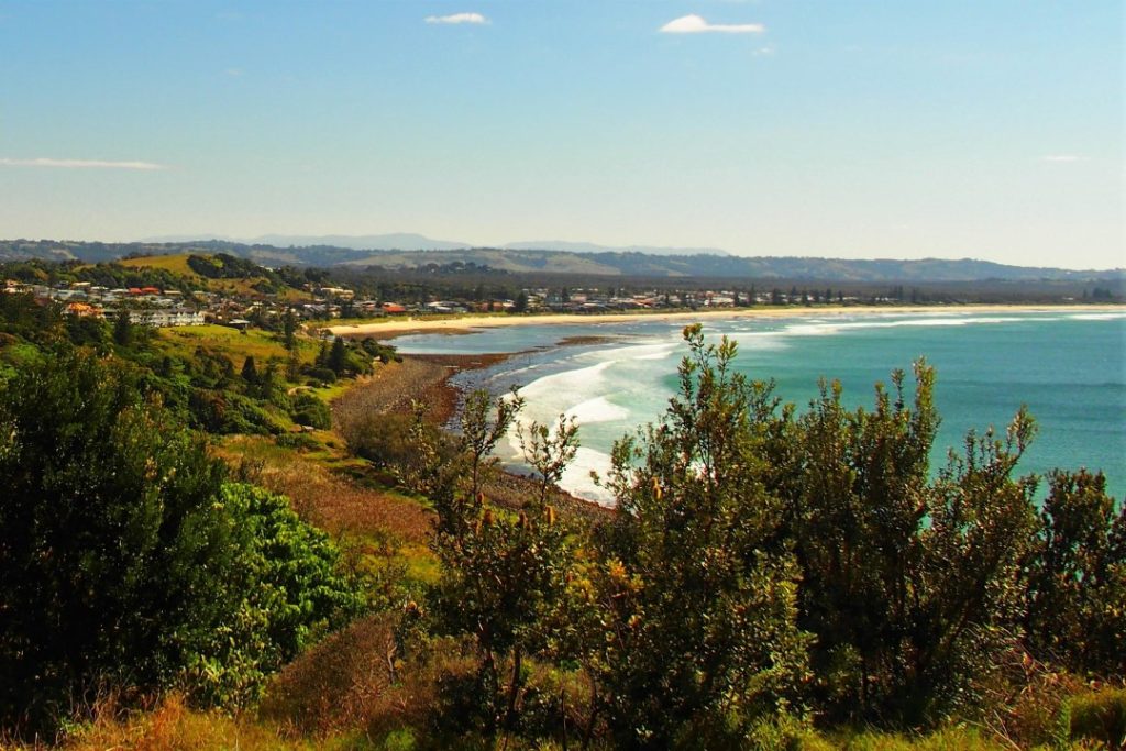 A scenic view from Pat Morton Lookout overlooking the coastline of Lennox Head, with waves crashing onto the shore and lush greenery framing the landscape—a popular spot among the things to do in Ballina NSW for breathtaking views and coastal walks.