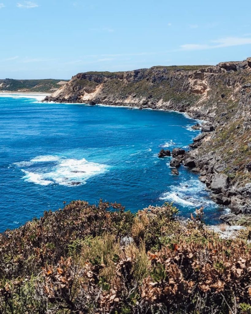 Rocky coastal cliffs at Tookulup Lookout, Windy Harbour WA, with vibrant blue waters and waves crashing along the rugged shoreline, showcasing the scenic beauty of Western Australia's coastline.