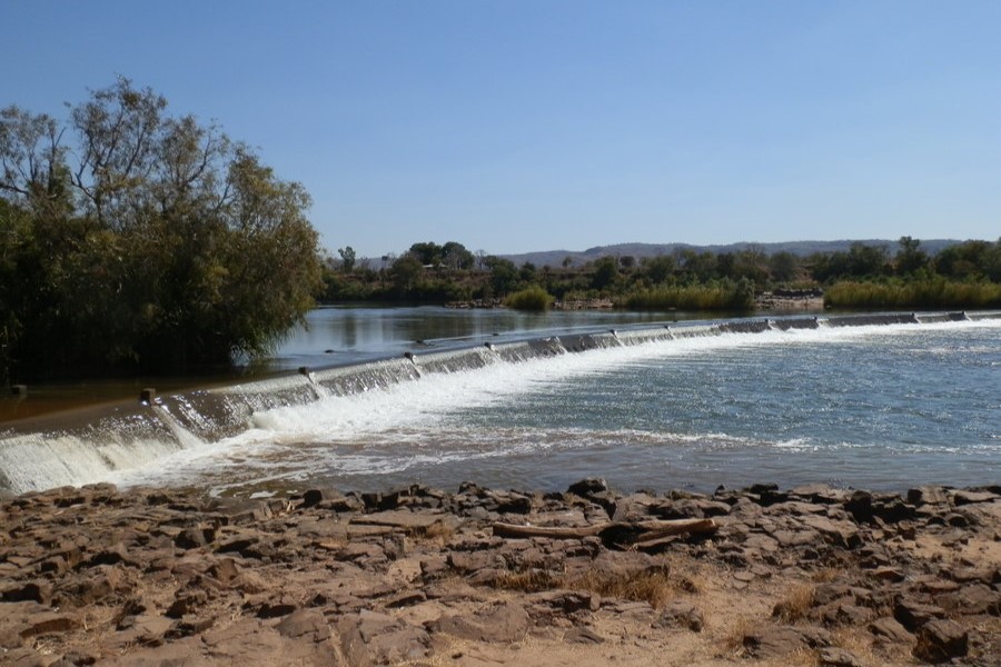 Ivanhoe Crossing on the Ord River near Kununurra, showing a shallow flowing river over a rocky crossing under a clear blue sky.