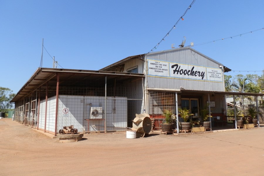 Exterior of the Hoochery Distillery, a rustic corrugated metal building advertising Kimberley cane spirit and whisky in Kununurra