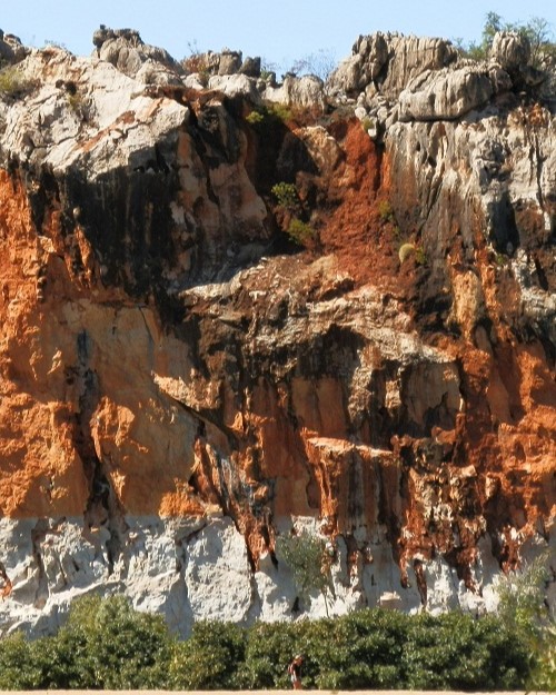 Close-up of colorful limestone cliffs at Danggu Gorge, showcasing dramatic orange and white rock formations.