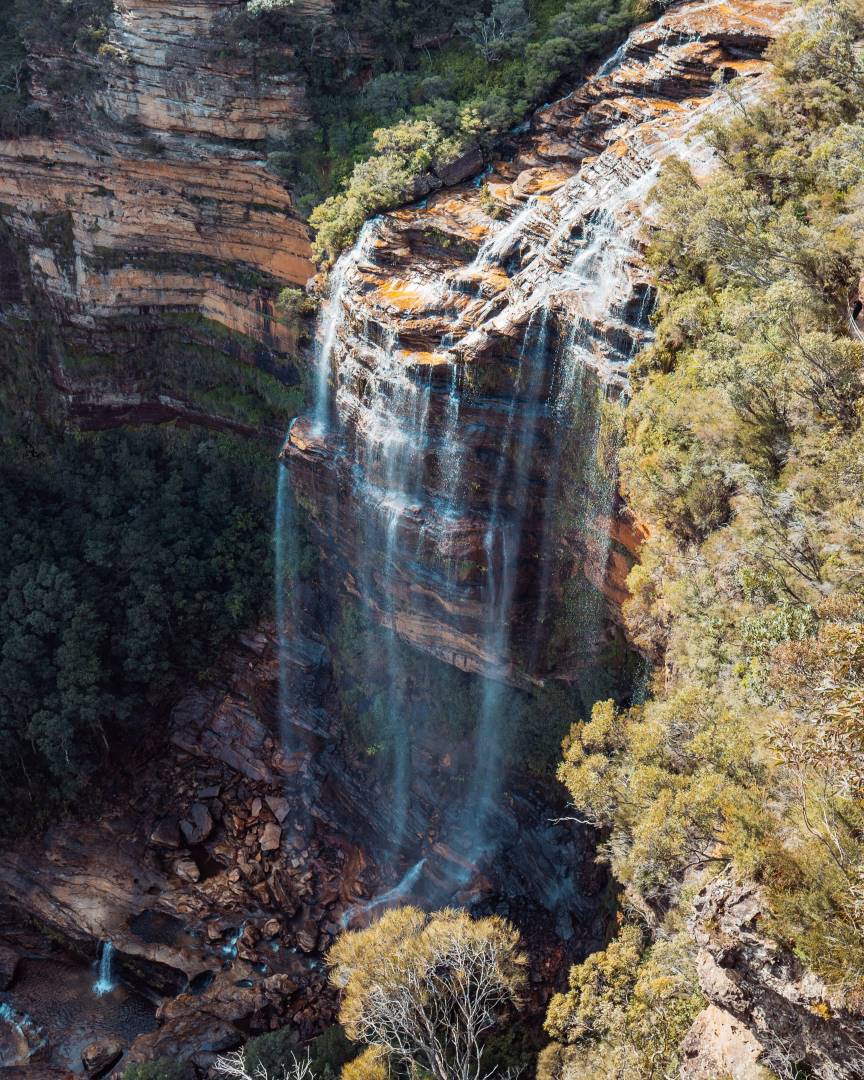 The majestic Wentworth Falls cascading down a steep cliff face in the Blue Mountains, a must-visit stop on the best Blue Mountains tours. The surrounding bushland enhances its beauty