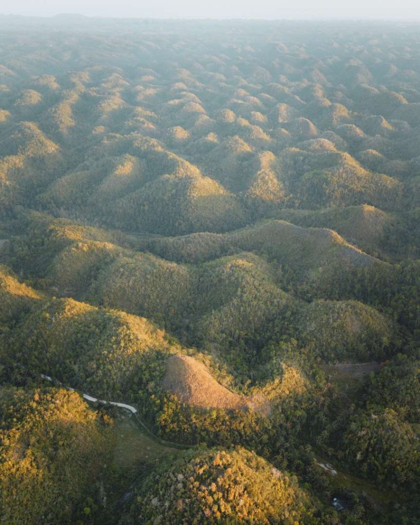 An aerial view of the Chocolate Hills in Bohol, stretching endlessly across the landscape, proving that natural wonders are part of the affordable Philippines travel cost experience.