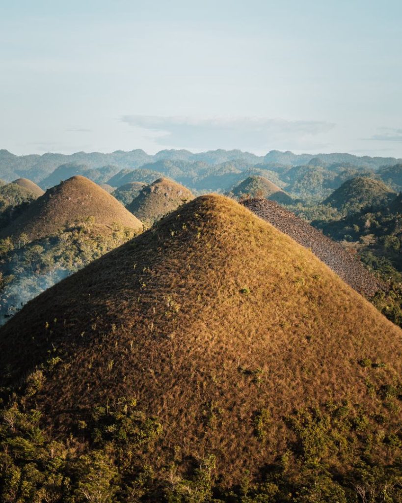 A stunning view of the Chocolate Hills in Bohol, with their distinctive rounded mounds stretching into the distance. One of the most famous places to see in the Philippines, offering a unique geological wonder.