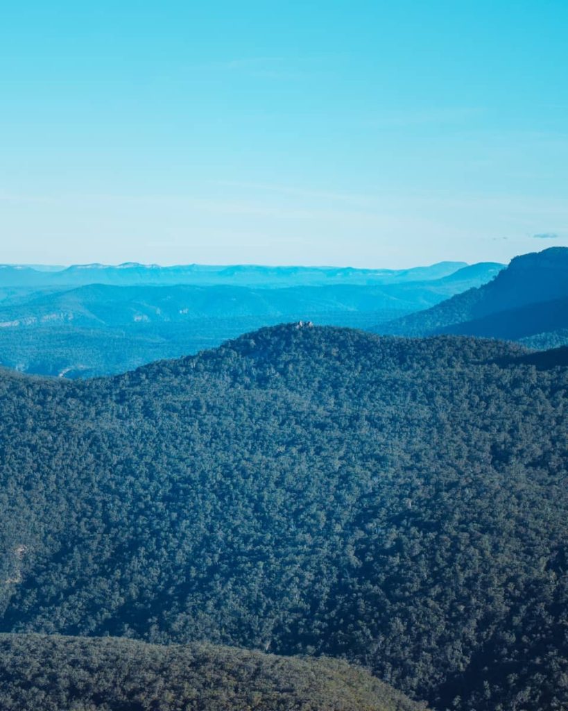 A panoramic view of endless forested ridges and blue-hazed mountains, seen from the Ruined Castle hike—ideal for Blue Mountains weekend itinerary adventurers.