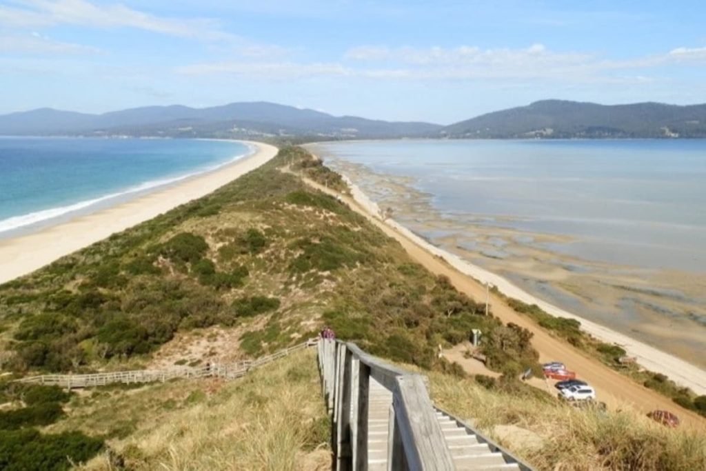 A view from the stairs at The Neck on Bruny Island, Tasmania, showing a narrow isthmus dividing the ocean and bay—an iconic lookout on scenic road trips in Australia.
