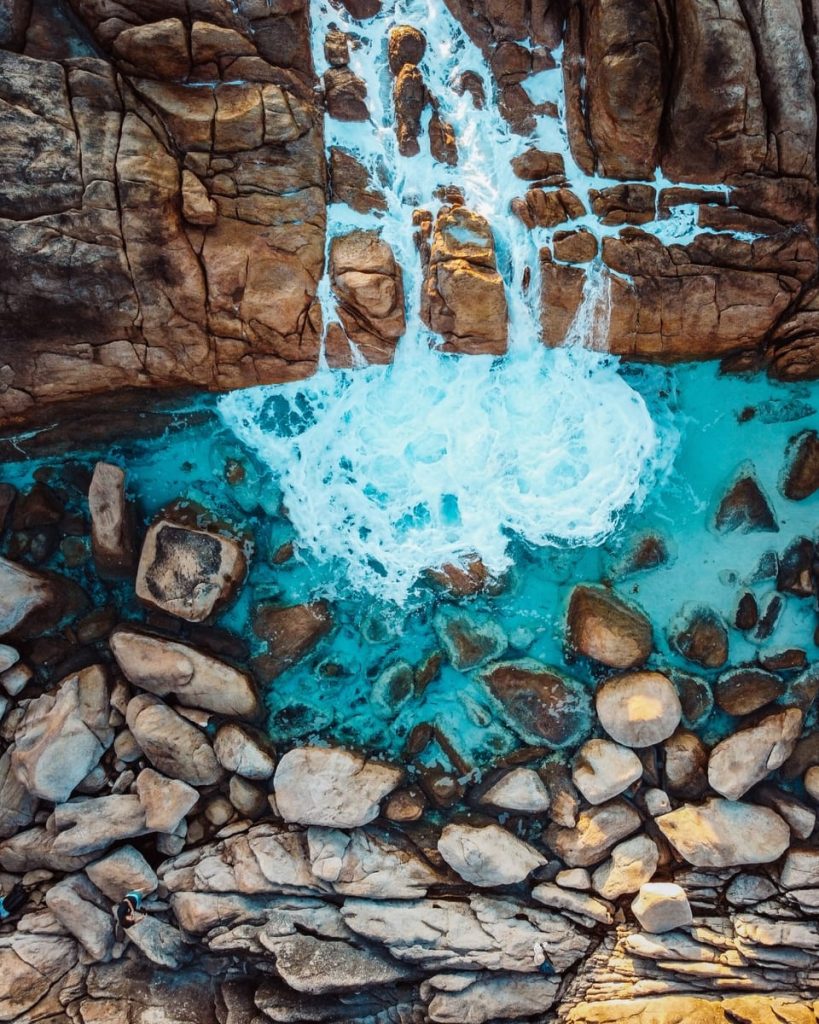 Aerial view of waves crashing into rock pools at Injidup Natural Spa in Yallingup, a dramatic natural wonder on the Perth to Albany road trip route.