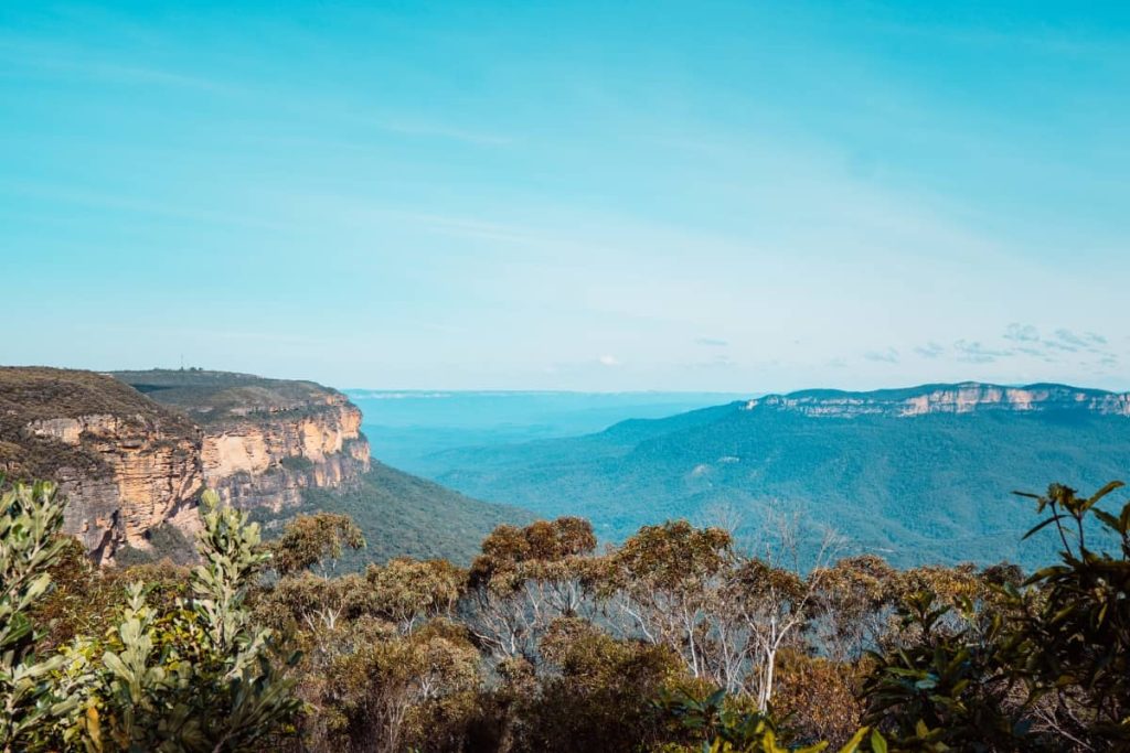 Panoramic view from Scenic World showing sandstone cliffs, forested valleys, and distant plateaus in the Blue Mountains, NSW.