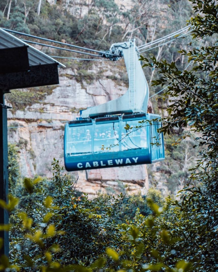 Scenic World cableway glides past dense bush and sandstone cliffs in the Blue Mountains, transporting visitors across the valley.