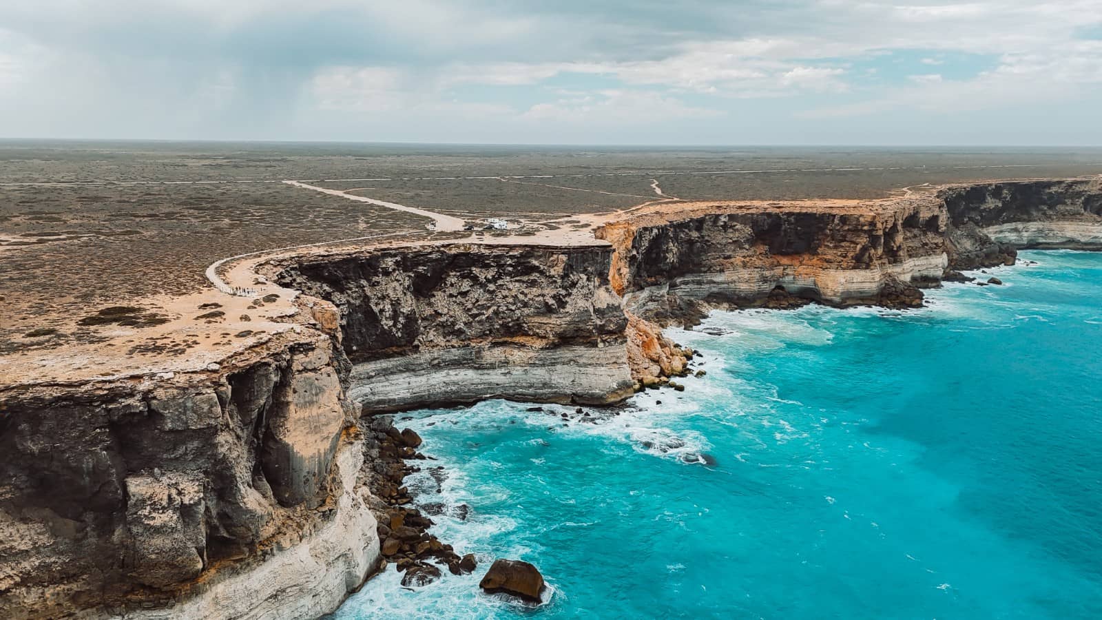 Aerial view of the Bunda Cliffs, with the ocean crashing at the base. Part of any road trip on the Nullarbor